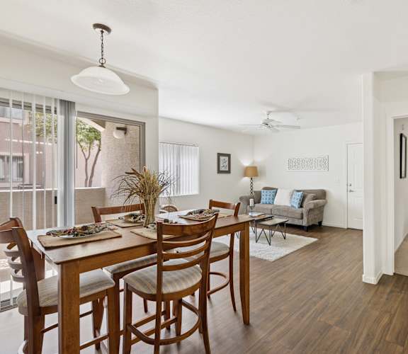 A dining room with a table set for six with a view of the outside.