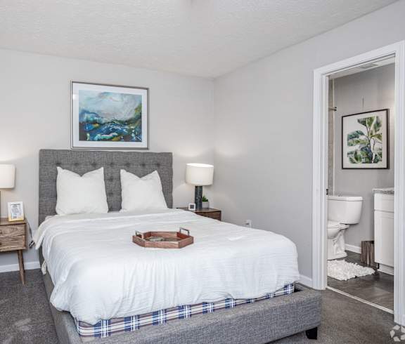 a bedroom with a bed and a bathroom with a toilet