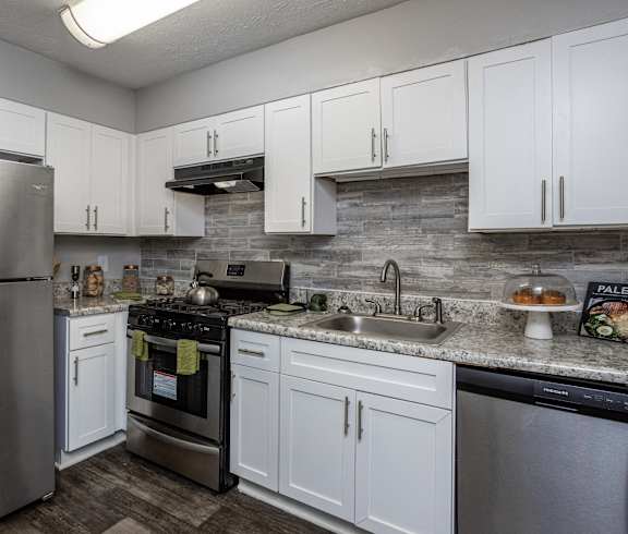 a kitchen with stainless steel appliances and white cabinets