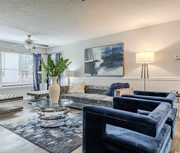 a living room with couches and a table and a ceiling fan