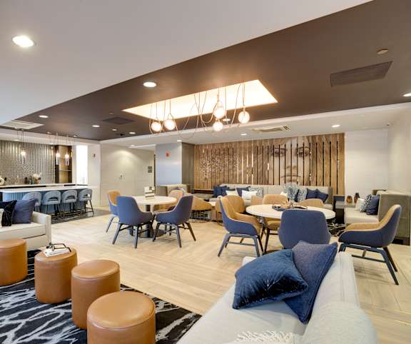 A modern living room with a dining area and a kitchen in the background.