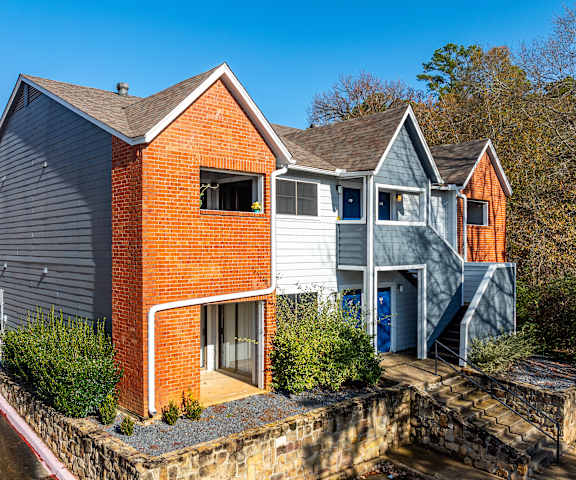 A modern house with a red brick facade and a grey roof.