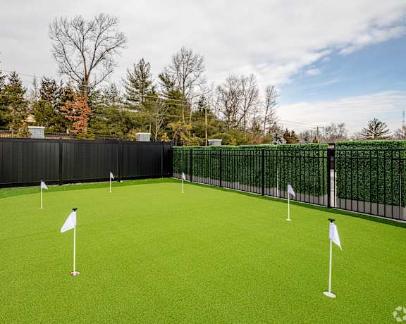 A golf course with green grass and white flags.