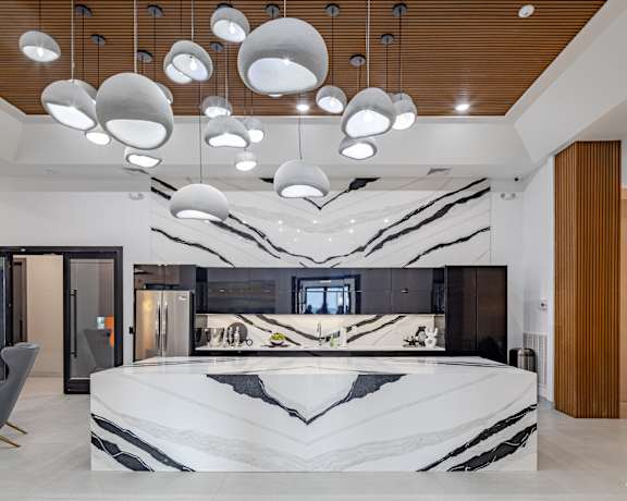 A modern bathroom with a marble countertop and a large mirror.