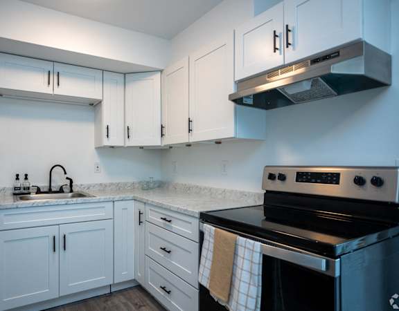 a kitchen with white cabinets and black appliances and a sink
