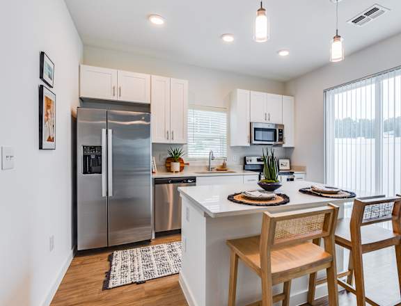 an open kitchen and dining area with stainless steel appliances and a large window