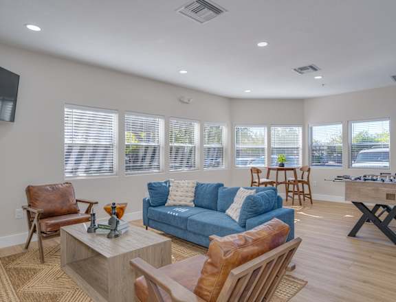 a living room with a blue couch and chairs and a table with a chessboard