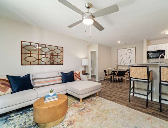 an open living room and kitchen with a ceiling fan