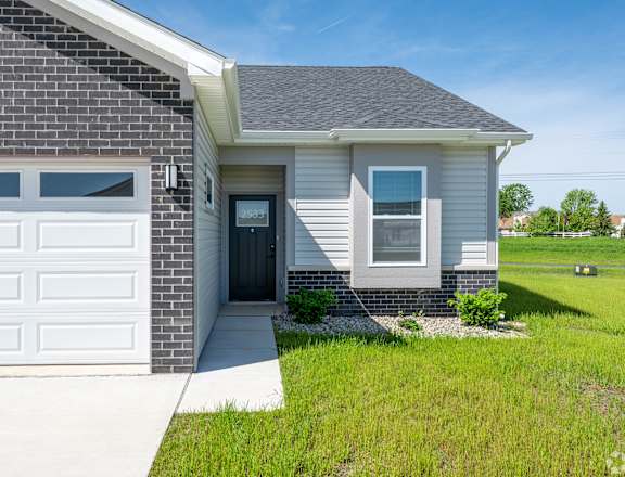 A house with a grey roof and a white garage door.at Concord Crossing, Indiana