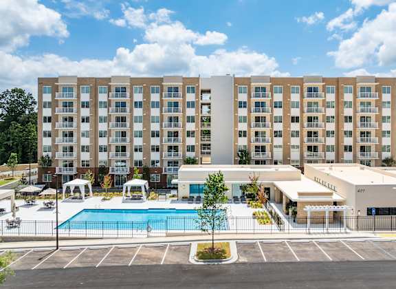 A large building with a pool in front of it.