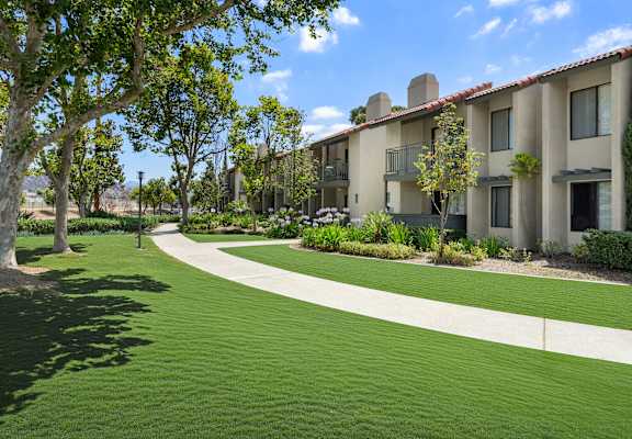A grassy area in front of apartment buildings.