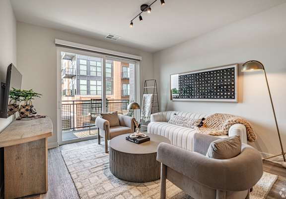 an open living room with a couch and chairs and a tv