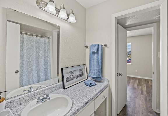 A bathroom with a white sink and a mirror above it. at La Bella Apartments, Fort Worth, TX, 76116