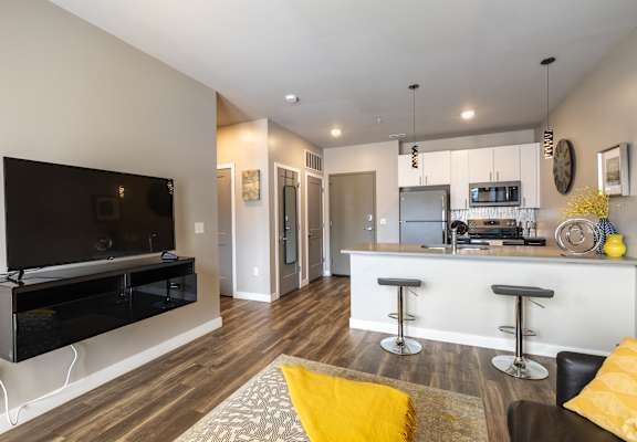 A modern living room with a bar area and a television. at 1400 Russell Apartments, Saint Louis, MO, 63104