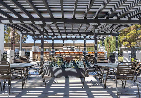a patio with tables and chairs and a pergola