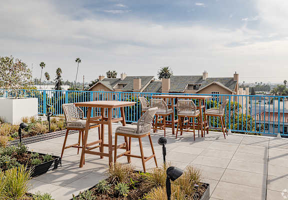 A patio with a table and chairs overlooking a street.