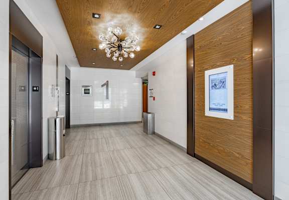 A hallway with a chandelier and a framed picture on the wall.