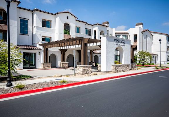 A street view of a Vintage at Ranchero Creek community with a white building and a red curb.at Anacapa Canyon, Camarillo, 93012