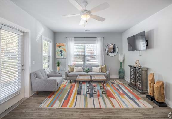 a living room with a ceiling fan and a rug