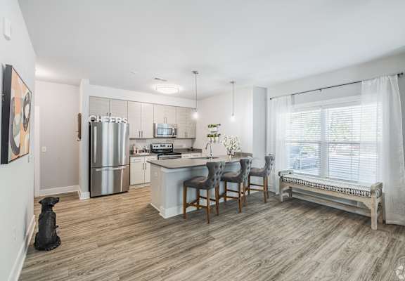 an open kitchen and dining area with a stainless steel refrigerator