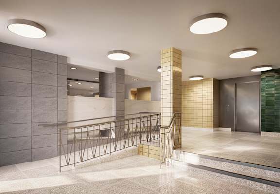 the lobby of a building with a staircase and a railing