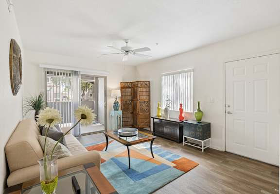 A living room with a beige couch, a coffee table, and a rug.