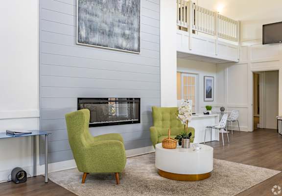 A living room with a green chair and a fireplace.