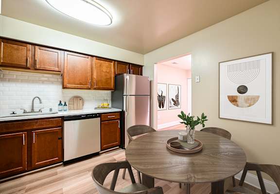 A kitchen with a table and chairs in the foreground.