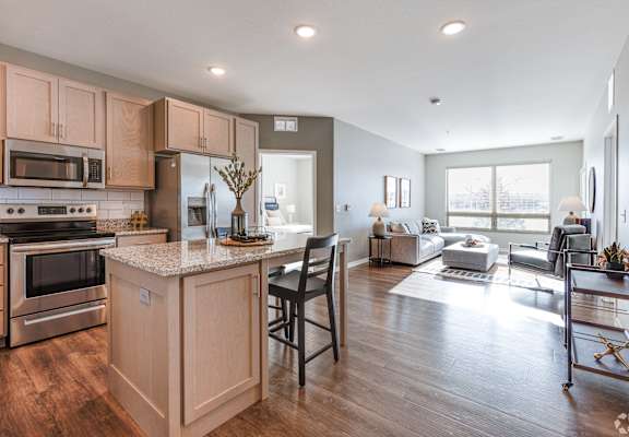 A kitchen with wooden cabinets and a granite countertop.