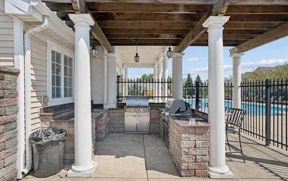 A patio with a pool in the background.