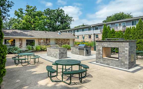 A sunny day at the outdoor seating area of a building with stone fireplaces.
