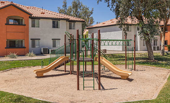 a playground with two slides and a swing set