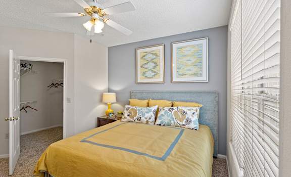 a bedroom with a bed and a ceiling fan