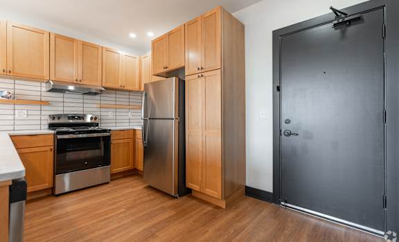 Kitchen with Brown Wooden Cabinets at The Yard Apartments, Louisville, KY