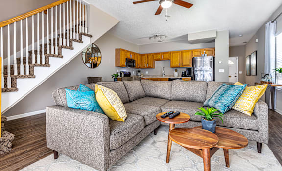 A living room with a grey couch and a wooden coffee table.
