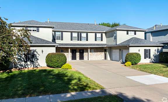 A large, modern house with a grey roof and white walls.