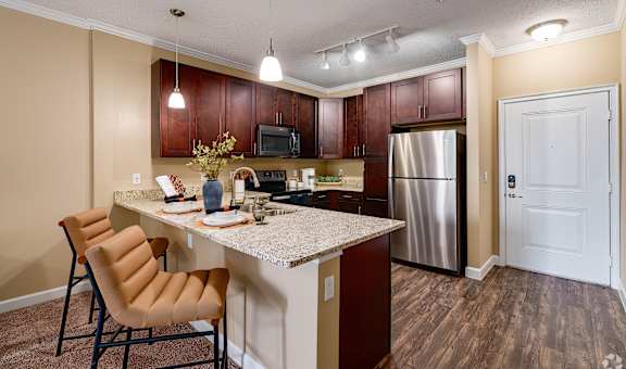 A kitchen with a table and chairs.