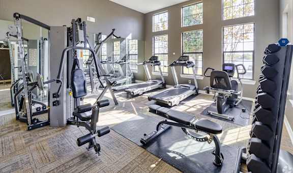 spacious gym with cardio equipment and windows at the preserve at greatstone