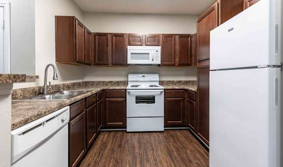 Sugar Mill Apartments in Addis, LA photo of a kitchen with white appliances and wooden cabinets