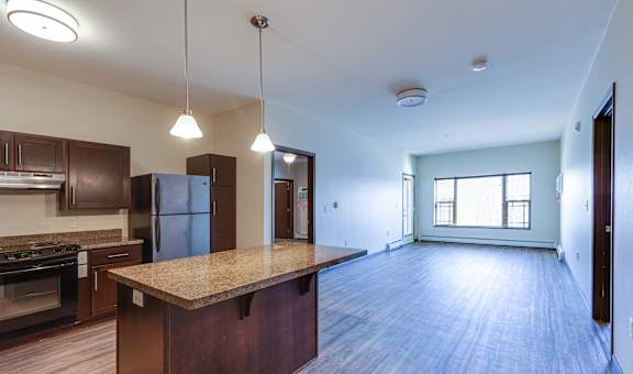 A kitchen with a refrigerator, cabinets, and a countertop.