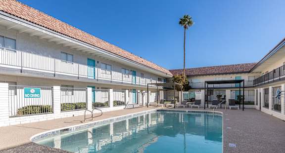 A pool in front of a building with a sign that says "NOWLDS".