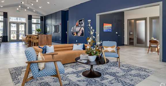 a living room with blue walls and a couch and chairs