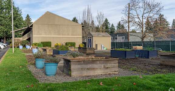 A beige building with a brown roof and a fence in the background.