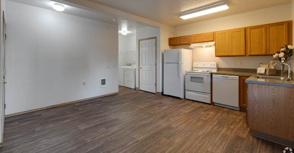 A kitchen with white appliances and wooden cabinets.