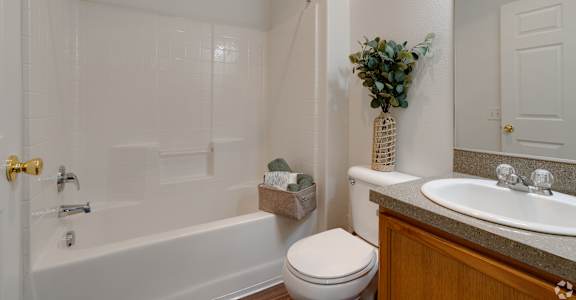 A white bathroom with a toilet, sink, and shower.