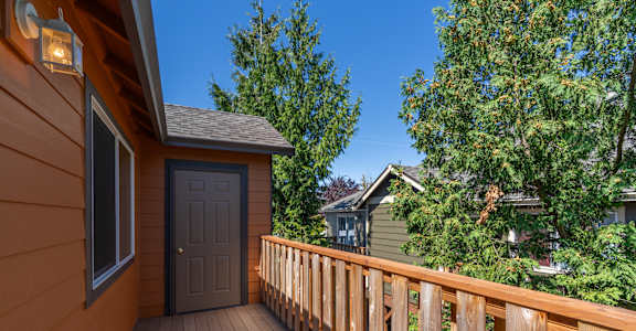 A wooden deck with a brown door and a window.