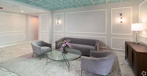 a living room with gray couches and a glass coffee table