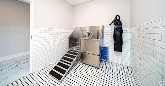 a kitchen with a sink and apron in a white room with a door