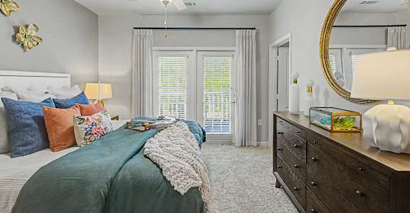 A bedroom with a bed, dresser, and mirror.