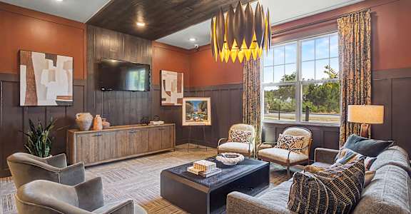 A living room with a grey couch, a coffee table, and a wooden cabinet.